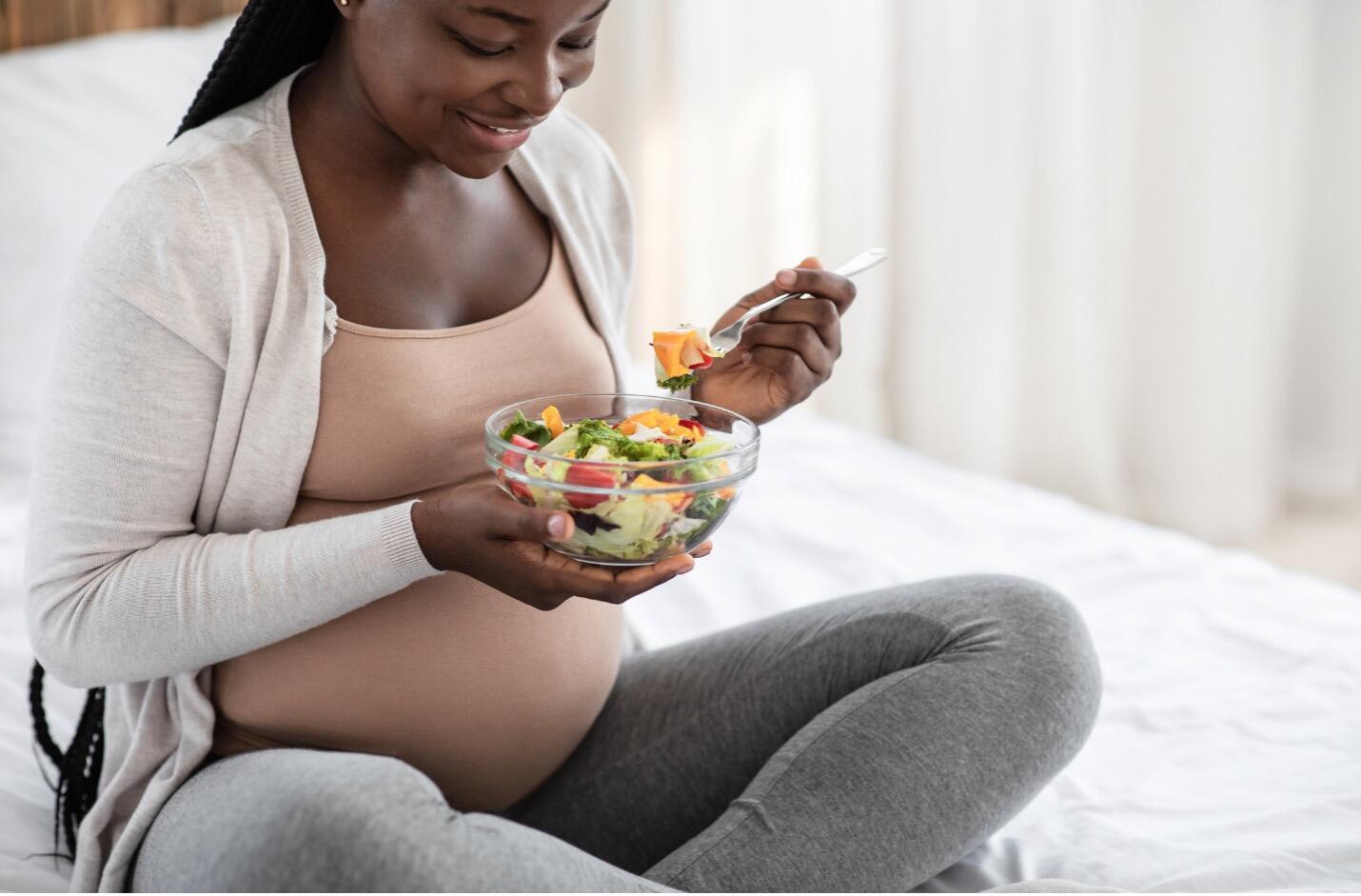 PREGNANT WOMAN SITTING ON BED